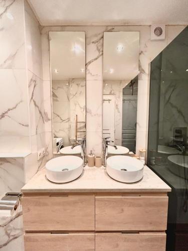 une salle de bain avec deux lavabos et deux miroirs dans l'établissement Bright & Peaceful - Free Parking and Breakfast - Full apartment with 2 rooms, à Nice