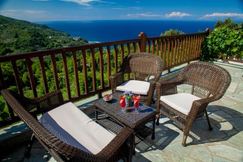 three chairs and a table on a balcony with the ocean at Lions Nine in Mouresi