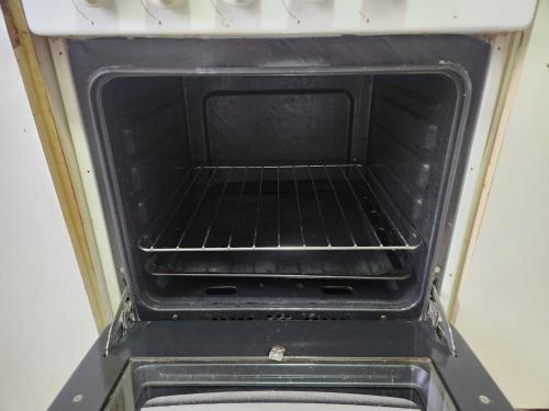 an oven with an open door with a rack in it at Cabañas Kernayel in Pucón
