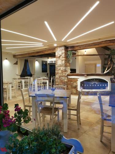 a dining room with a table and a fireplace at Agriturismo Tuluschene in Gavoi