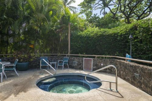 bañera de hidromasaje en un patio con sillas y mesa en Kahana Villas E408, en Napili-Honokowai
