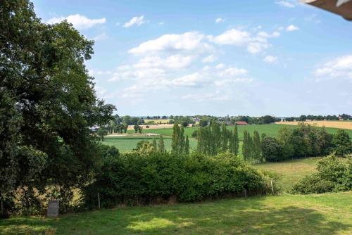 une vue d'un champ avec des arbres et de l'herbe dans l'établissement La Hulotte, à Saint-Malon-sur-Mel