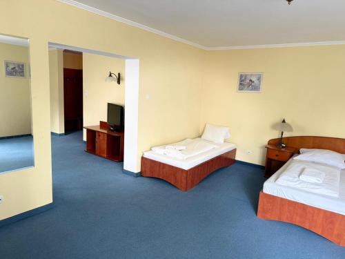 a hotel room with two beds and a television at Pokoje Stary Rynek in Elblag
