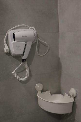a phone in a bathroom next to a toilet at Gyumri House Midtown in Gyumri