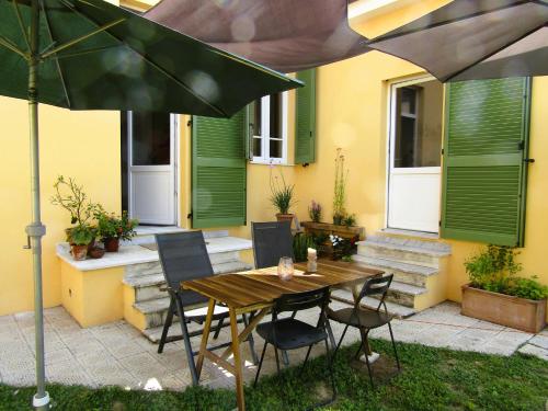 a patio with a wooden table and chairs and an umbrella at Il Tulipano in Camaiore