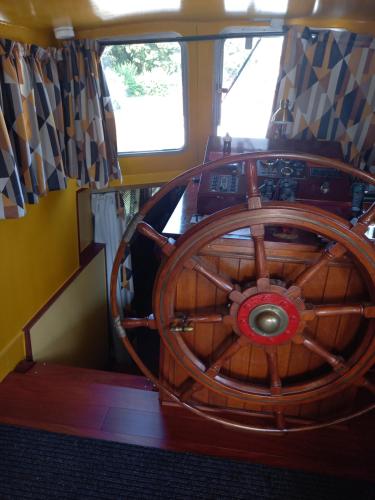 a large wooden steering wheel on a boat at Péniche Jeannine in Lobbes