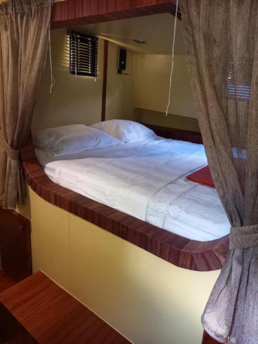 a bedroom with a bunk bed with white sheets at Péniche Jeannine in Lobbes