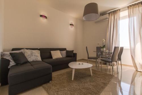 a living room with a black couch and a table at Captain Emo City Apartments in Pula
