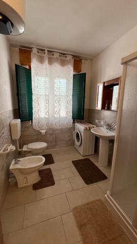 a bathroom with two toilets and a sink and a shower at Villa Palma Di Mare in Portopalo