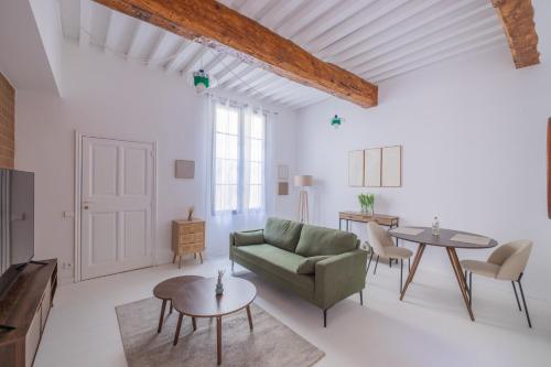 a living room with a green couch and tables at Appartement Belle Lettre 7 in Aix-en-Provence