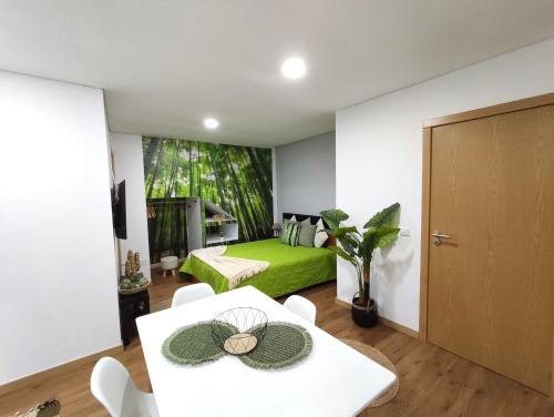 a room with a green bed and a table and chairs at Casa Dos Passos 0 in Guarda