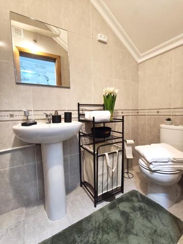 a bathroom with a sink and a toilet and a mirror at Casa Dos Passos 0 in Guarda