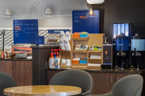 a cafe with a table and chairs and bottles of wine at Holiday Inn Express & Suites Cold Lake by IHG in Cold Lake