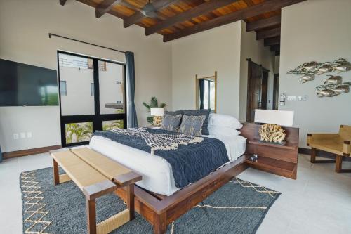 a bedroom with a large bed and a table at Prana Maya Island Resort in Placencia Village