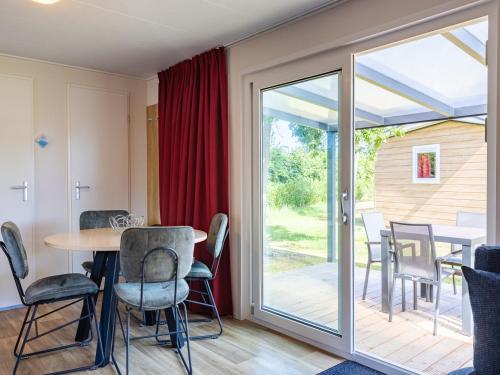 a dining room with a table and chairs and a sliding glass door at Villa in Burgh-Haamstede with Garden in Burgh Haamstede