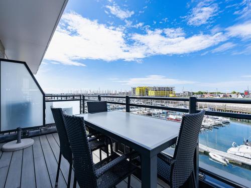 a table on a balcony with a view of a harbor at Apartment in Sint-Annaland with Water Views in Sint Annaland