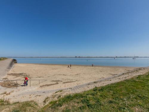 a person riding a bike on a beach at Apartment in Sint-Annaland with Water Views in Sint Annaland