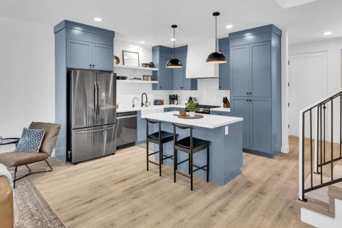 a kitchen with blue cabinets and a kitchen island with chairs at The Park Street Hideaway in Downtown Paso in Paso Robles
