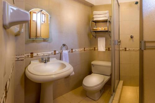 a bathroom with a sink and a toilet and a mirror at El Virrey Boutique in Cusco