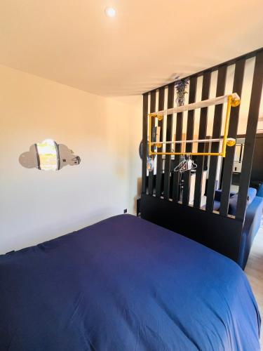 1 dormitorio con cama azul y cabecero negro en L etoile au cœur de la nature, en Rosselange