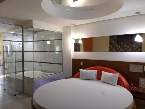 a bedroom with a large bed and a bath tub at Hotel e Motel Rarus in Igaratinga