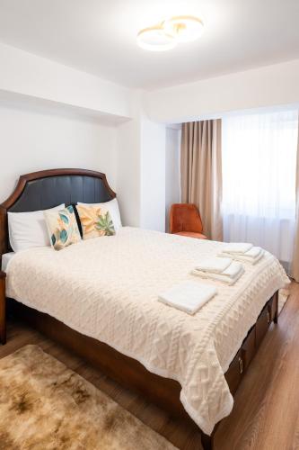 a bedroom with a large bed and a chair at Apartament de închiriat Accommodation in Suceava