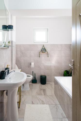 a bathroom with a sink and a tub and a toilet at Apartament de închiriat Accommodation in Suceava