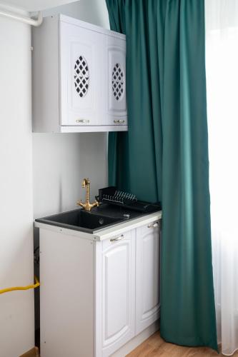 a kitchen with a sink and a blue curtain at Apartament de închiriat Accommodation in Suceava