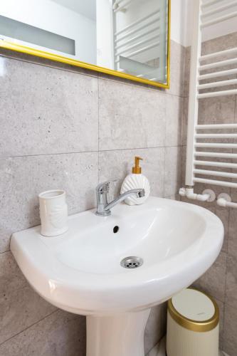 a white sink in a bathroom with a mirror at Apartament de închiriat Accommodation in Suceava
