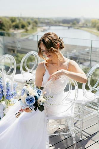 a woman in a white wedding dress holding a bouquet at Sheraton Grand Krakow in Kraków