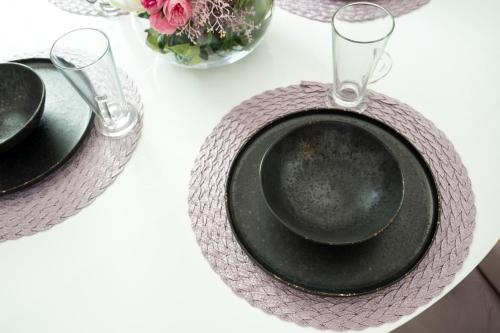 a table with two black plates and glasses on it at Apartament de închiriat Accommodation in Suceava