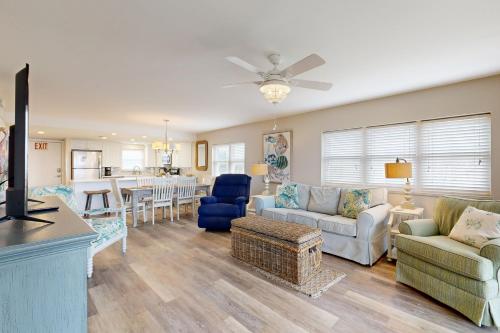 Oceanfront corner condo with sunrise-view balcony, pool & 1-minute walk to beach في فرناندينا بيتش: غرفة معيشة مع أريكة وطاولة