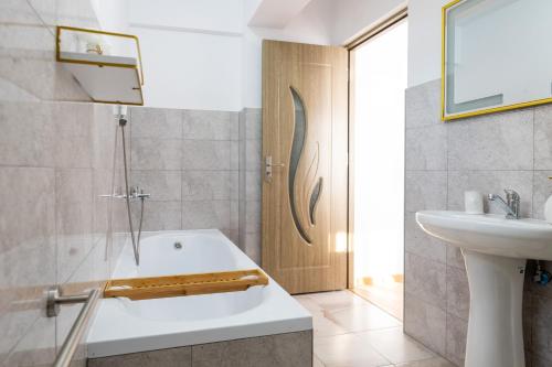 a bathroom with a bath tub and a sink at Apartament de închiriat Accommodation in Suceava