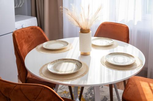 a white table with plates and a vase on it at Apartament de închiriat Accommodation in Suceava