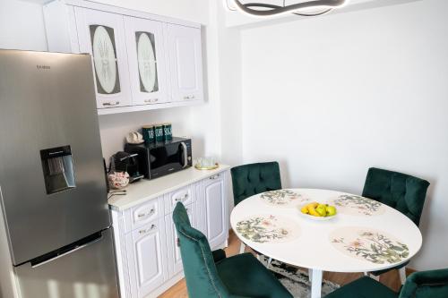 a kitchen with a table and chairs and a refrigerator at Apartament de închiriat Accommodation in Suceava