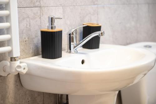 a bathroom sink with two soap dispensers on it at Apartament de închiriat Accommodation in Suceava