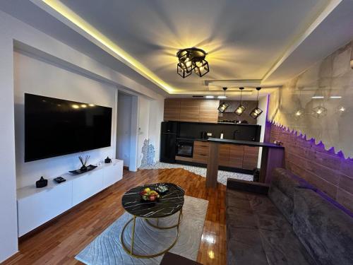 a living room with a large television and a table at Astelliora Apartment Sarajevo Old Town Free Parking in Sarajevo