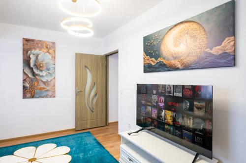 a living room with a television and a painting on the wall at Apartament de închiriat Accommodation in Suceava