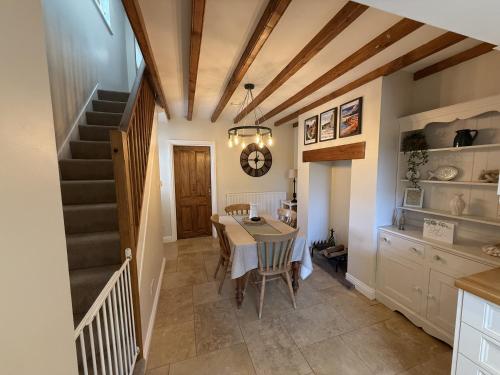 a dining room with a table and a staircase at Autumn Cottage in Filey