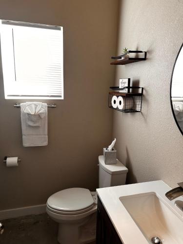 a bathroom with a toilet and a sink and a mirror at Lagoon Ranch RV Resort in Onalaska