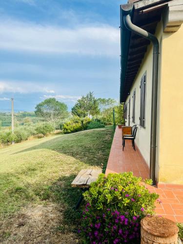 a bench on a brick walkway next to a building at Nibbio III - Entire house in the heart of Chianti in Lucardo