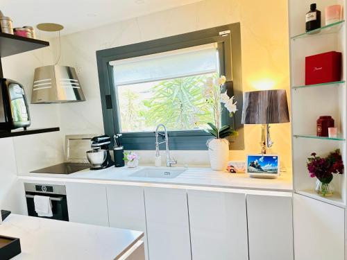 eine Küche mit Spüle und Fenster in der Unterkunft Private Rooftop Jacuzzi in La Celle-sous-Gouzon