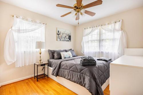 a bedroom with a bed and a ceiling fan at 3BR Home - Free Parking-WiFi Kitchen Laundry-Kids Friendly-Near DC & Downtown & Metro-Patio & Deck in Falls Church