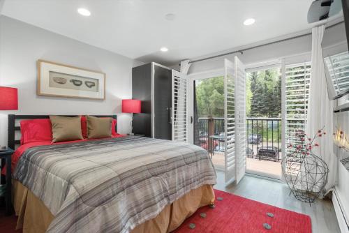 a bedroom with a large bed and a balcony at Cloudline Chalet Aspen Chic At South Point in Aspen