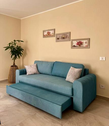 a blue couch in a living room with a plant at Villa Patrizia affittacamere con parcheggio privato in Como