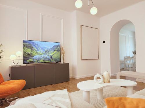 a living room with a flat screen tv on a cabinet at Velký luxusní apartmán se dvěma ložnicemi v centru Pardubic - WiFi, Netflix in Pardubice