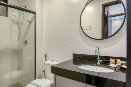 a bathroom with a sink and a mirror at Edificio Liv P.Verde Apto 906-Mandi Hospitalidade in Maceió