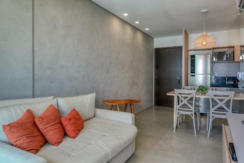 a living room with a couch and a kitchen at Edificio Liv P.Verde Apto 906-Mandi Hospitalidade in Maceió