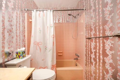a bathroom with a shower curtain and a toilet at 3BR Home - Free Parking-WiFi Kitchen Laundry-Kids Friendly-Near DC & Downtown & Metro-Patio & Deck in Falls Church