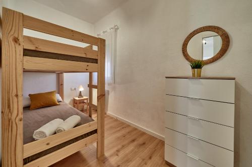 a bedroom with a wooden bunk bed with a mirror at NUEVO Apartamento Centro Lleida in Lleida